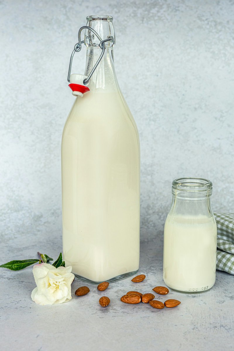 Bouteilles de boisson à l'amande et amandes éparpillées sur une table
