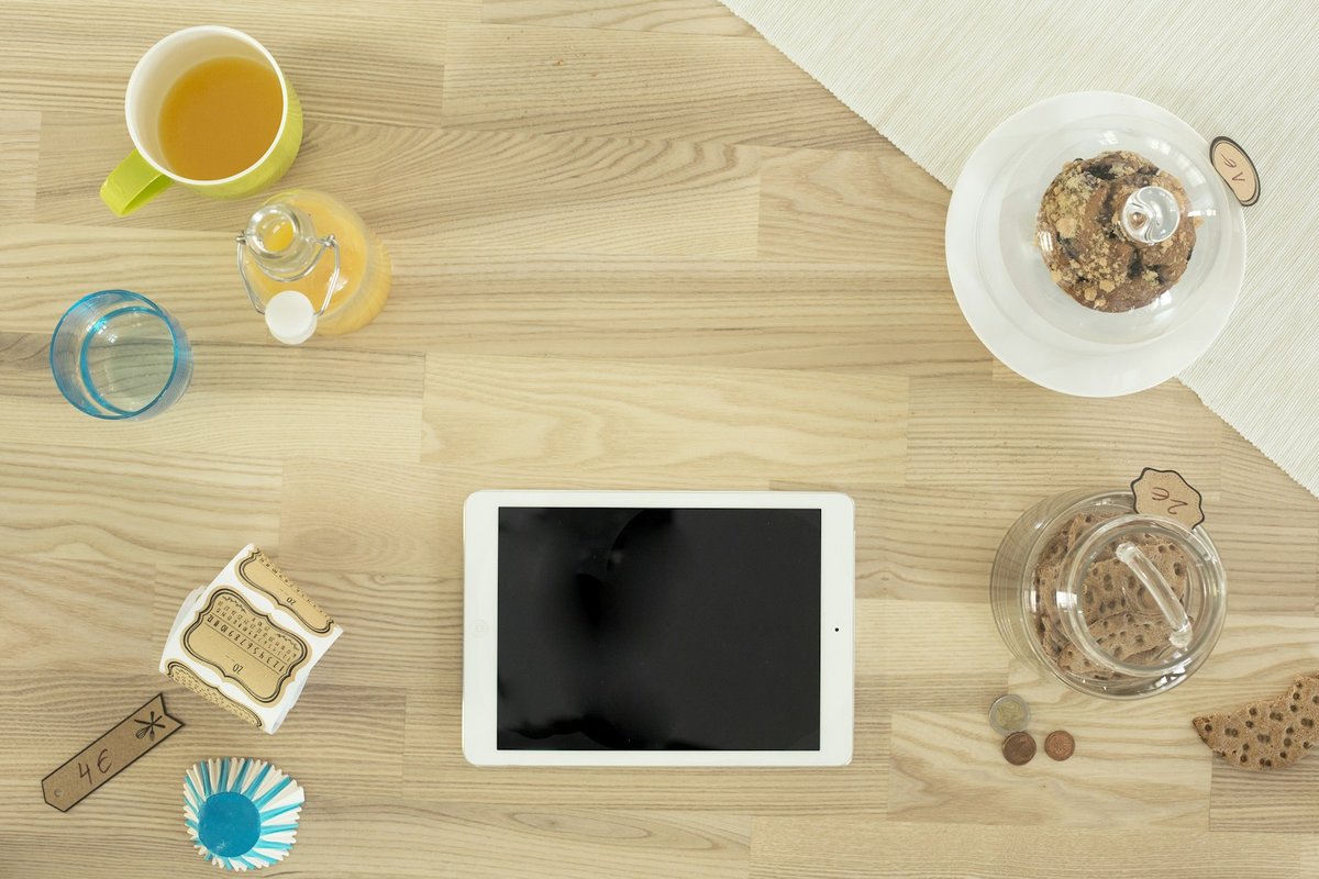 Tablette posée sur une table de petit déjeuner, vue du dessus