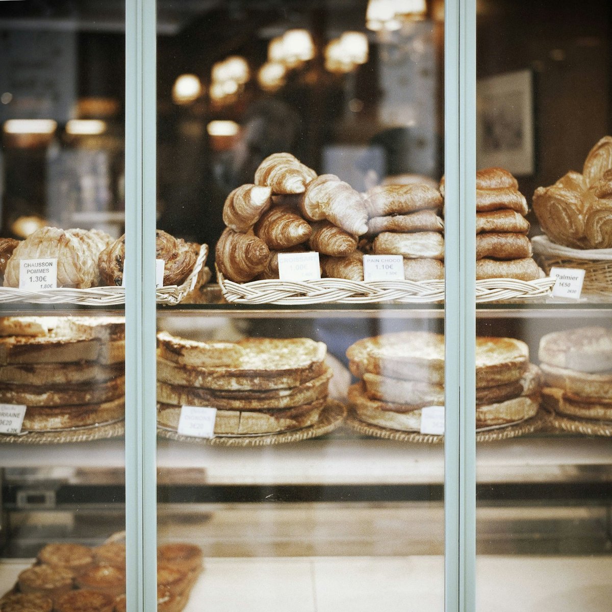 Vitrine de boulangerie : pains et viennoiseries rangés dans des paniers